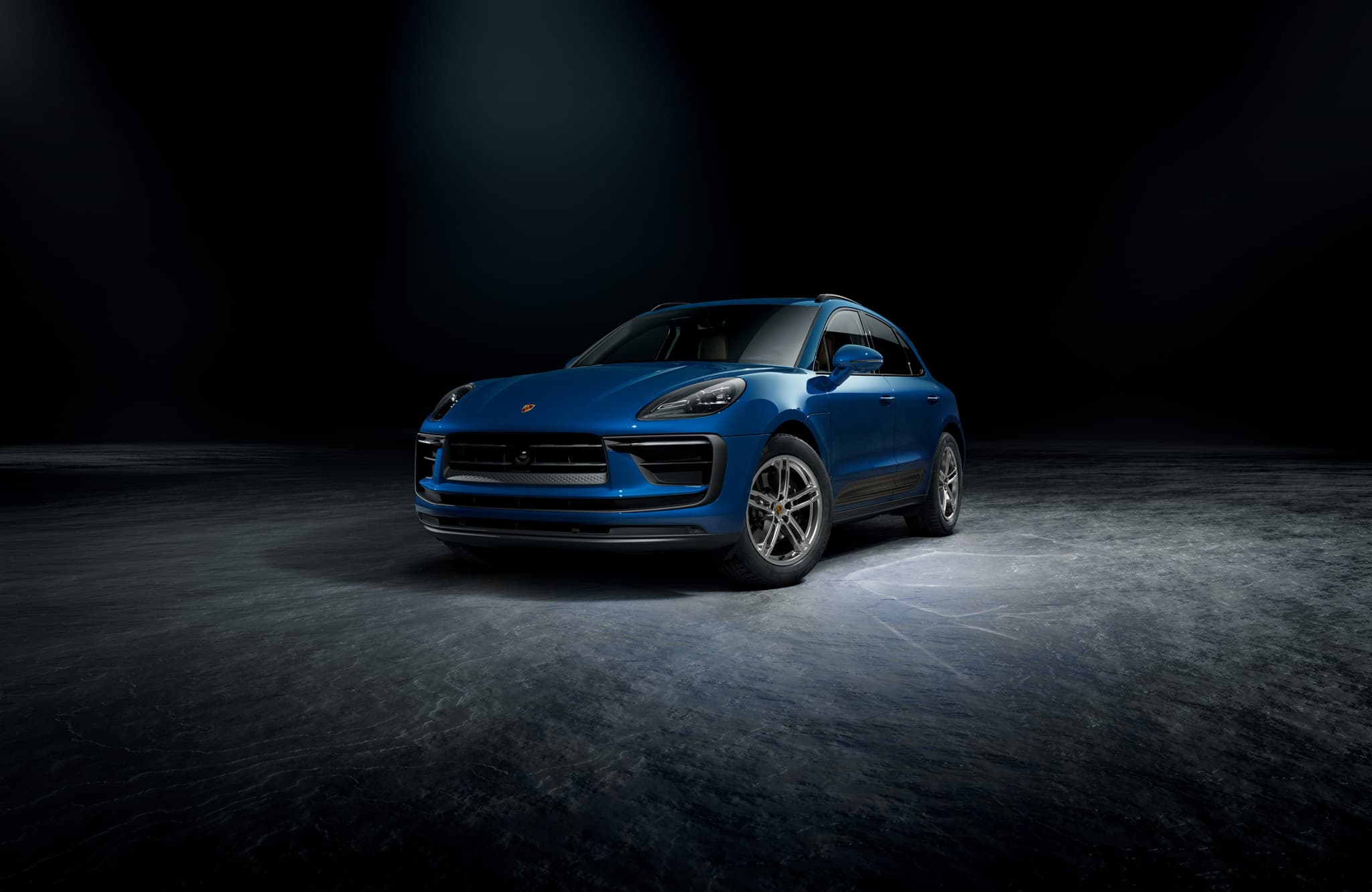 A Porsche Macan driving on an open road.